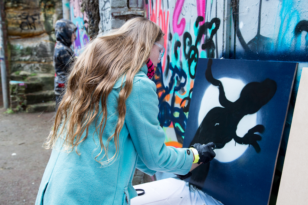 Photo of woman spray painting at the Streetsmart event