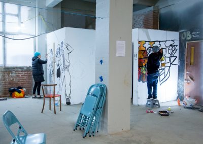 Photo of people painting onto the walls inside the Observer Building at the Streetsmart event